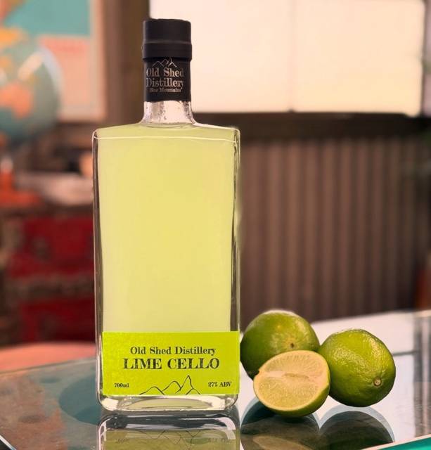 Bottle of Old Shed Lime Cello with fresh Bilpin limes